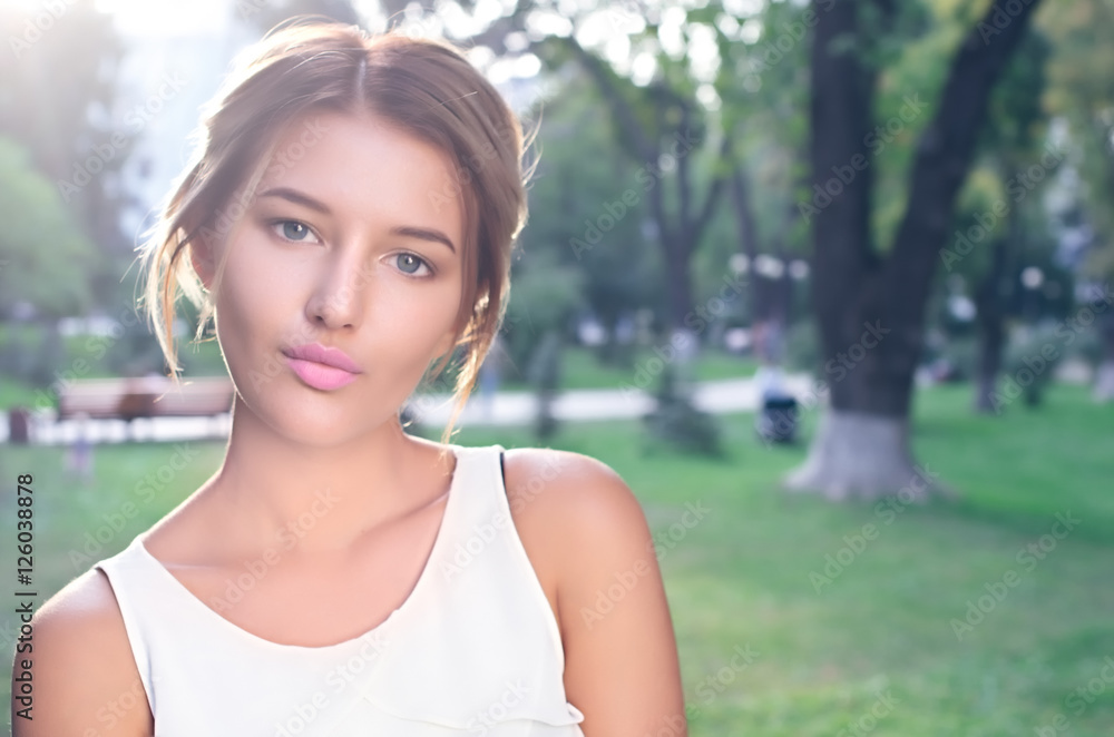 Bautiful girl wearing a white shirt poses in a city park Bautiful girl wearing a white shirt poses in a city park
