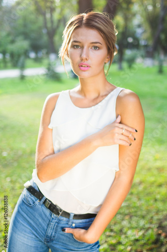 Bautiful girl wearing a white shirt poses in a city park