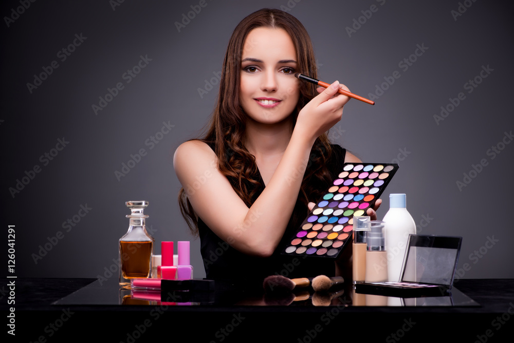 Beautiful woman applying make-up in fashion concept 