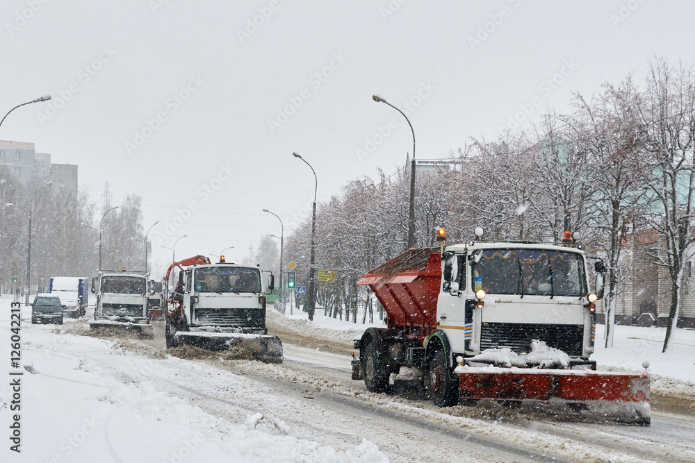 convoy of vehicles, shoveling snow in the street in the snow