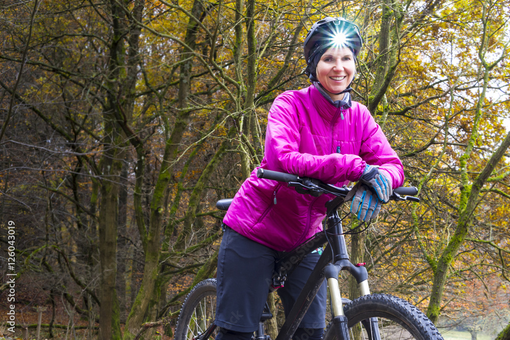 Obraz premium Frau auf dem Mountainbike mit Stirnlampe