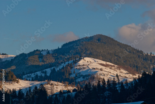 Top of mountains covered with snow lit by winter sun