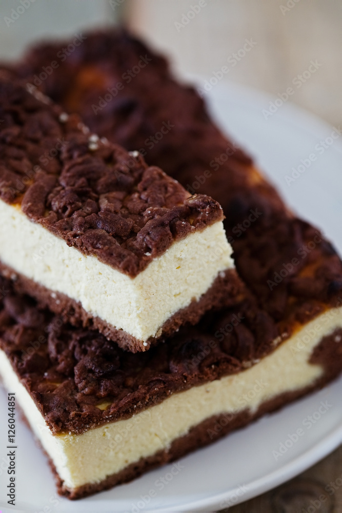 Chocolate Crumble Cheesecake. Slice of cheesecake with chocolate shortcrust pastry and chocolate crumble.