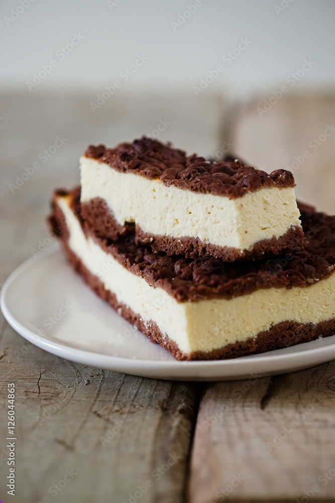 Chocolate Crumble Cheesecake. Slice of cheesecake bar with chocolate shortcrust pastry and chocolate crumble. Wooden table. Free text space. Chocolate Crumble Cheesecake. Slice of cheesecake bar with chocolate shortcrust pastry and chocolate crumble. Wooden table. Free text space.