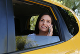 Beautiful young woman talking on phone in car