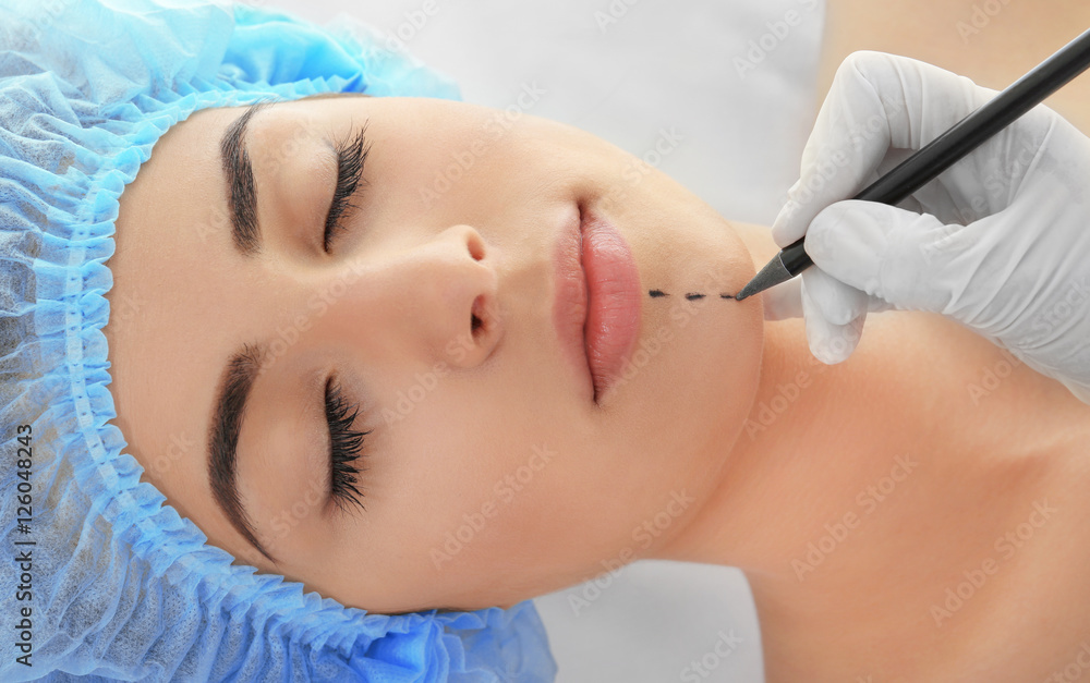 Plastic surgery concept. Hand in glove marking women face Plastic surgery concept. Hand in glove marking women face