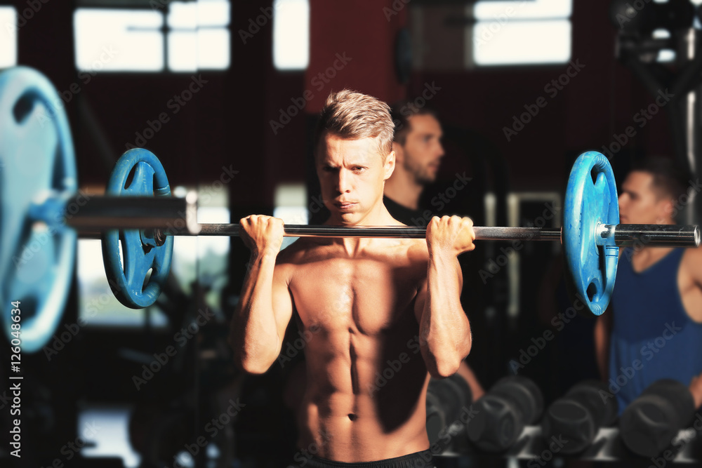 Athletic man training with barbell in gym Athletic man training with barbell in gym