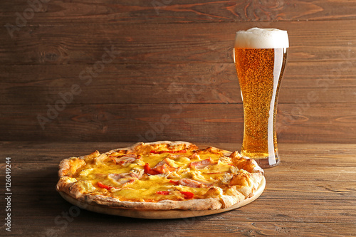 Tasty pizza with beer on wooden table