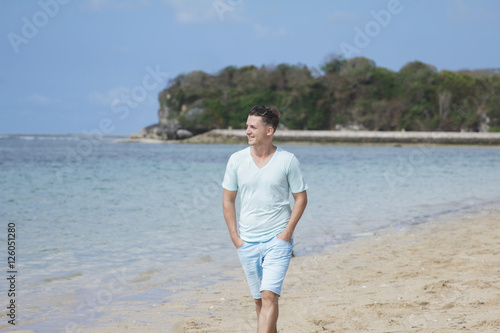 young man walking by at the beach © Odua Images