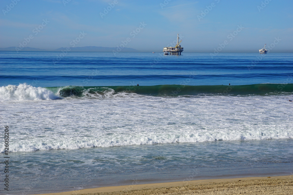 oil platform and surfers in ocean oil platform and surfers in ocean