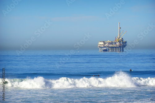 oil platform and surfer in ocean