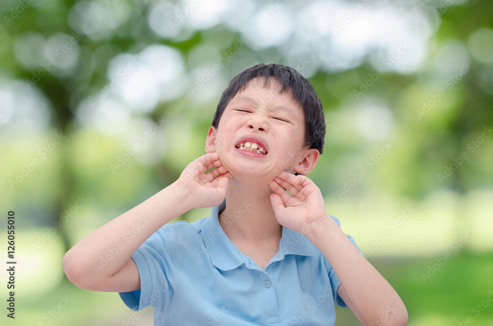 Young asian boy scratching his allergy face outdoor Young asian boy scratching his allergy face outdoor