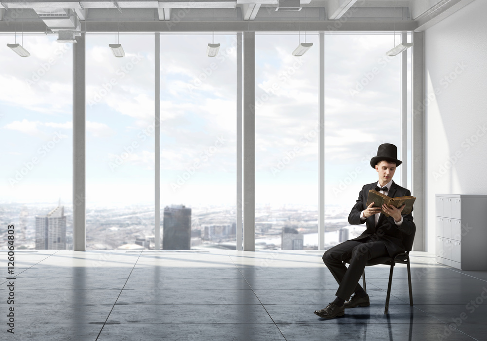 Elegant businessman read old book . Mixed media Elegant businessman read old book . Mixed media