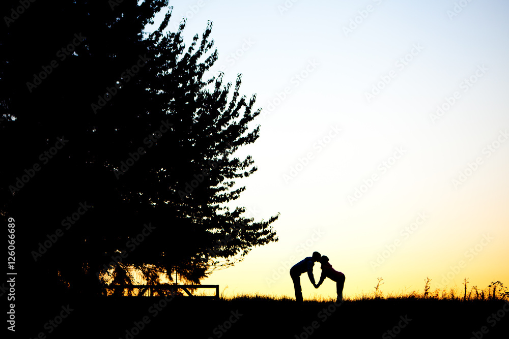 kissing couple silhouette at sunset