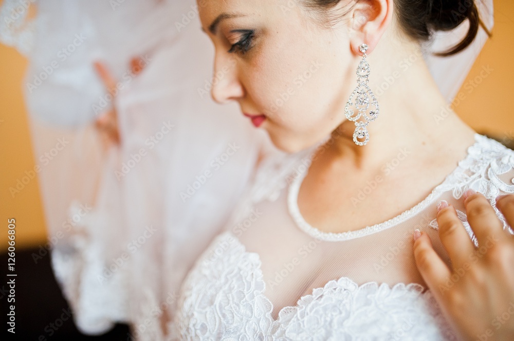 earrings on beautiful young brunette bride