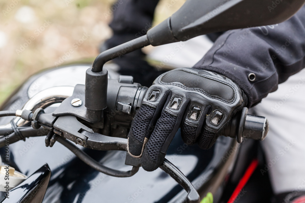 Biker on motorcycle, close-up view on hands on handlebars. Biker on motorcycle, close-up view on hands on handlebars.