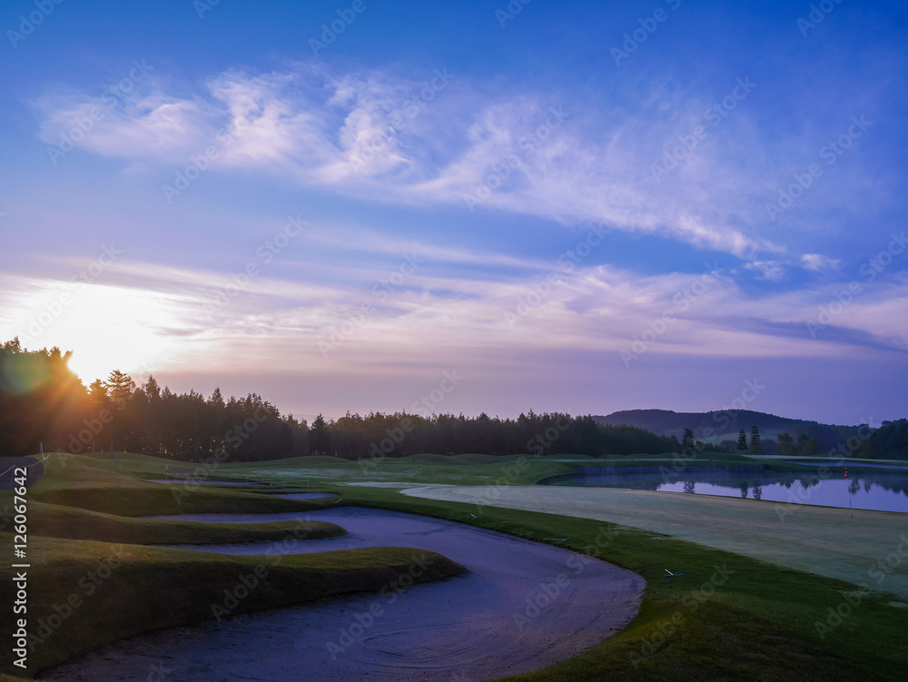 Fototapeta premium 北海道ゴルフ場の夜明け 朝焼けと池が美しい夏の朝のコース