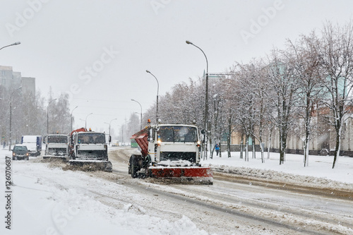column of special vehicles , shoveling snow in the street in the snow