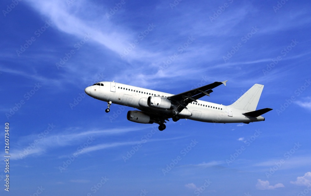 Passenger airplane take off under cloudy blue sky
