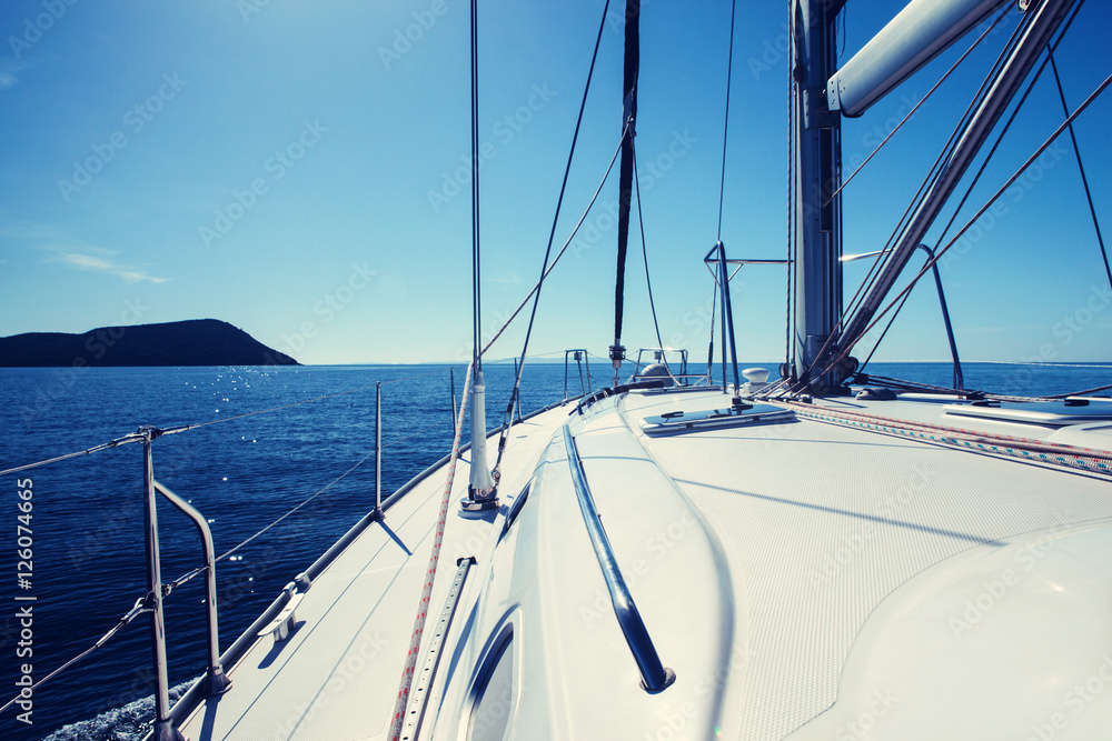 Fototapeta premium The white sails of yachts on the background sea and sky in the clouds