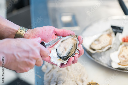 Photos Shucking fresh oysters with a knife