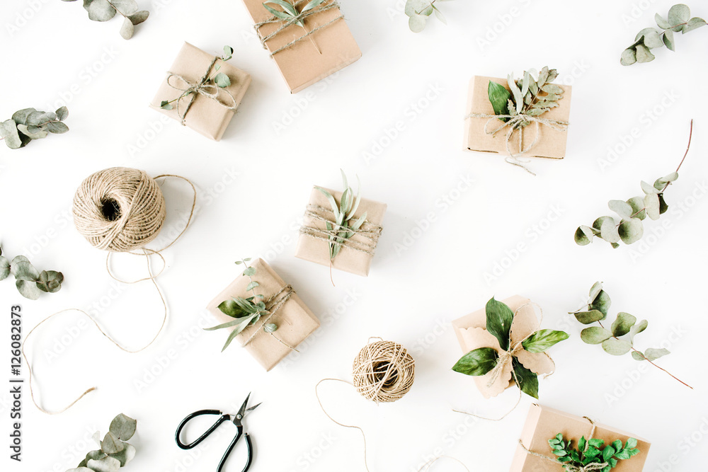 creative arrangement pattern of craft boxes and green branches on white background. flat lay, top view creative arrangement pattern of craft boxes and green branches on white background. flat lay, top view
