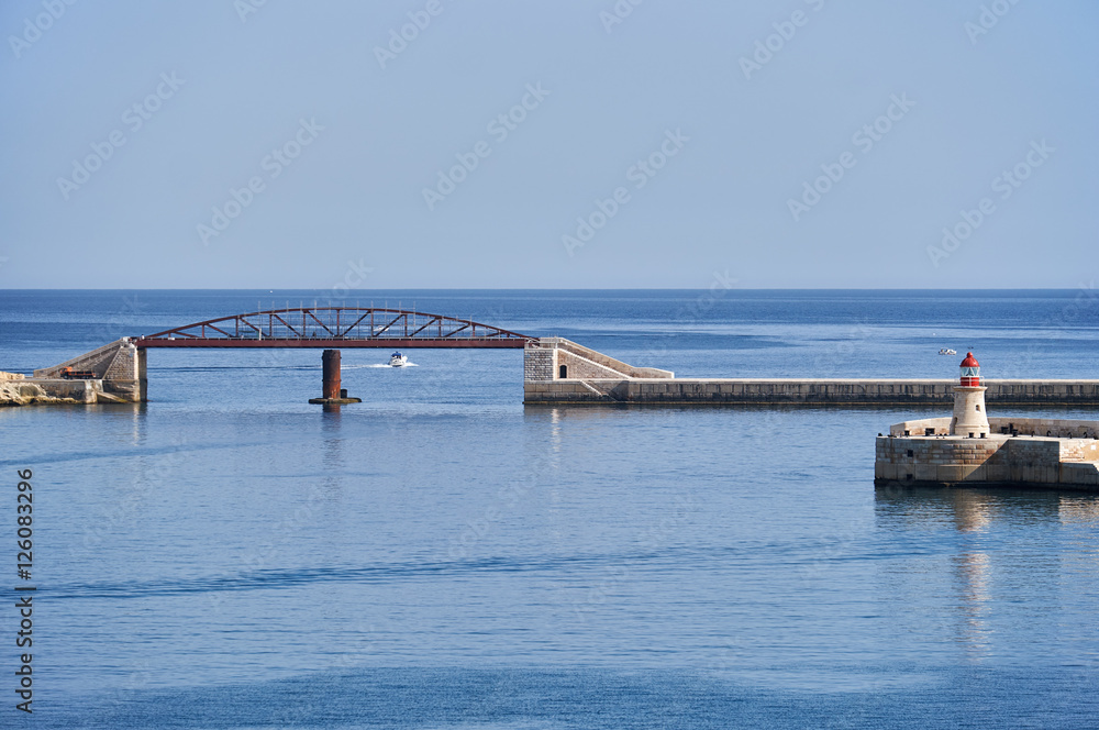 The view of the exit from the Grand Harbor with new Breakwater bridge and the Ricasoli Lighthouse,  Malta