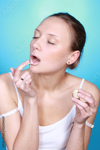 blinked girl with relish eating sweet licking her fingers