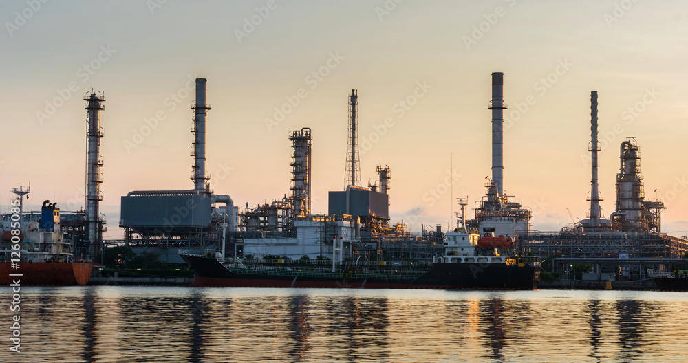Oil refinery industry plant. Silhouette of boat with oil refiner