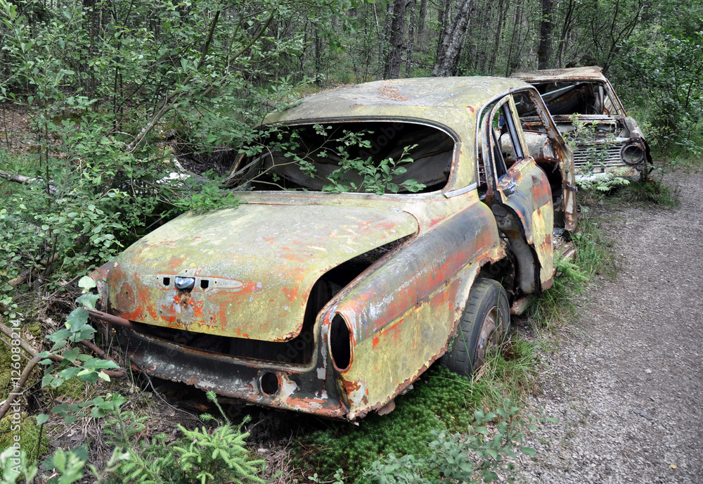 Övergiven, rostig bil i skogen. Övergiven, rostig bil i skogen.