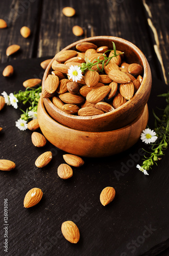 raw almonds in a wooden bowl selective focus