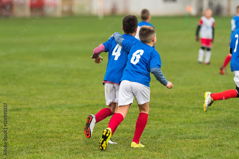 Obraz premium Young soccer boys hugging during football match