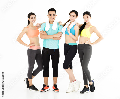 Happy young group of fit people standing in gym