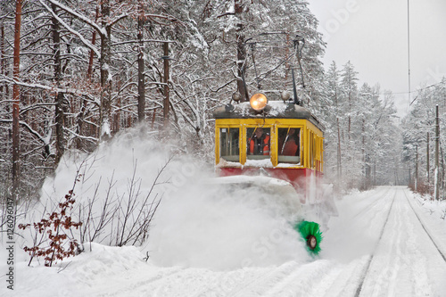 Tram with snow blower clears snow on public tram railways during a blizzard
