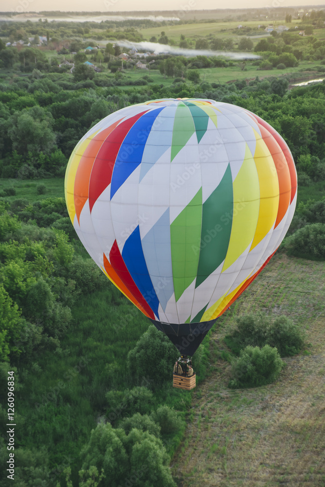 Obraz premium Balloon on a background of the beautiful green landscape