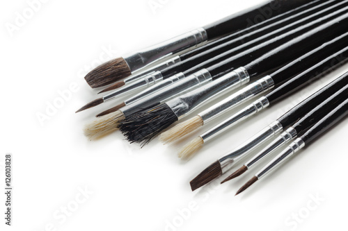 close up of paint brushes on white background