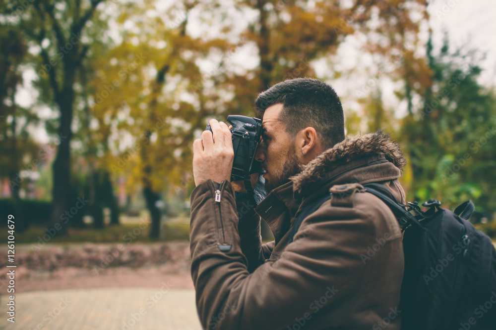 man photographer taking photo in the autumn park man photographer taking photo in the autumn park