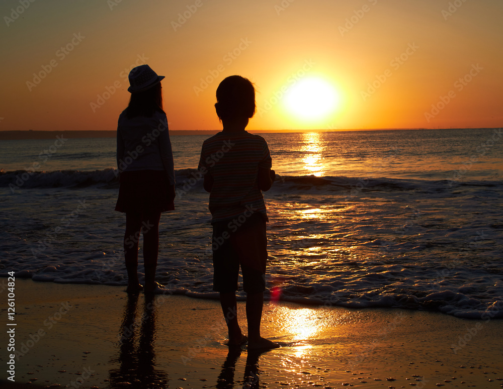 sister and brother sunset at the sea