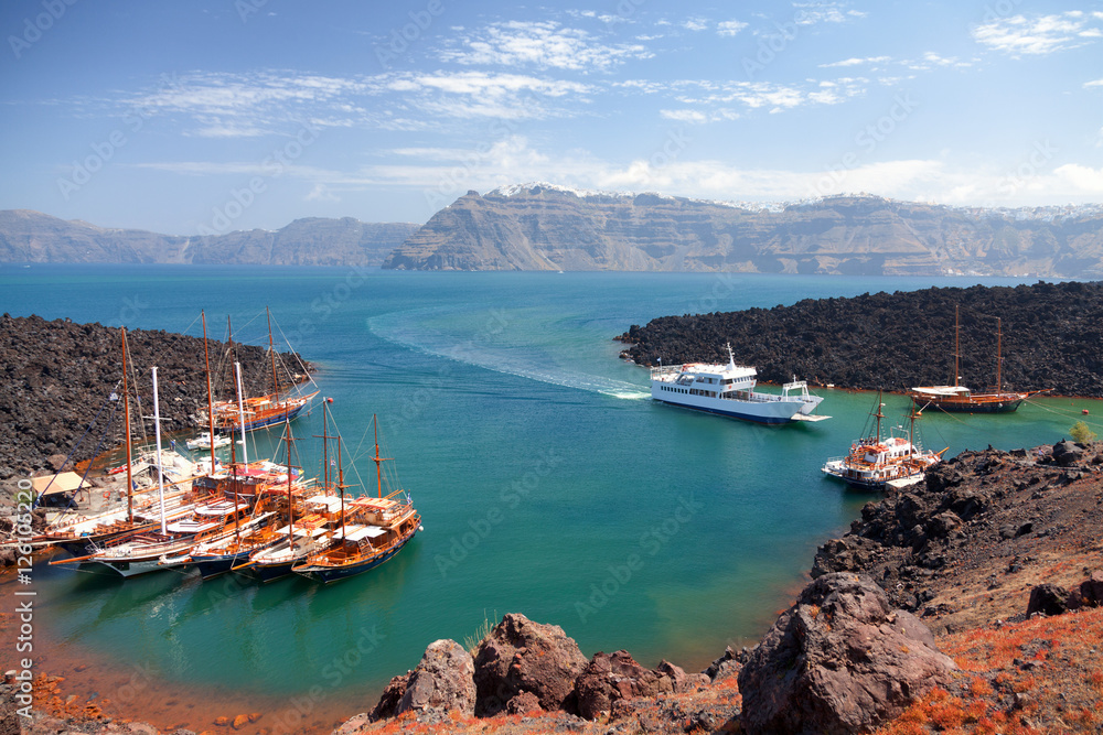 Nea Kameni volcanic island in Santorini, Greece. Ships from Fira