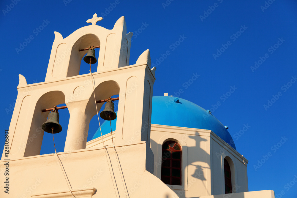 Blue dome church in Oia, Santorini at sunrise. Bells on foregrou