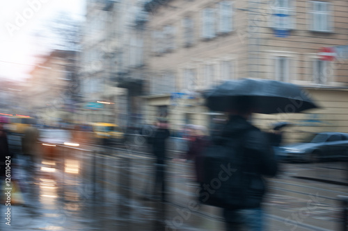 people walking in the street on a rainy day motion blurred