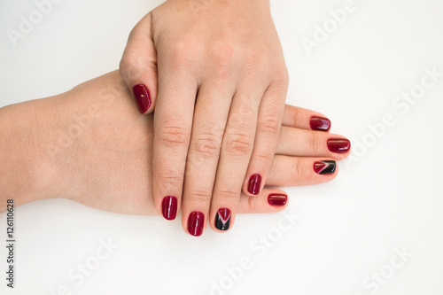 Canvas Print Closeup photo of a beautiful female hands with red nails on white background