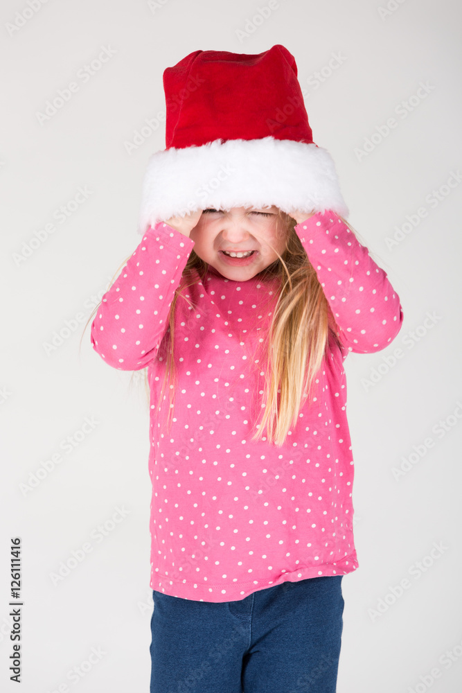 kleines Mädchen spielt mit Weihnachtsmütze kleines Mädchen spielt mit Weihnachtsmütze