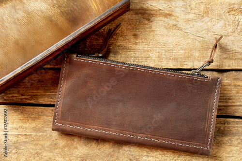 Brown leather purse on wood...