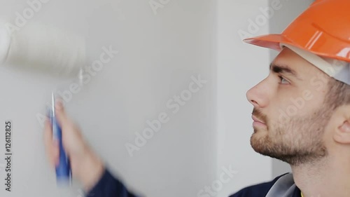 Man in a helmet painting wall