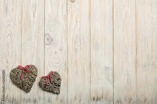 Concept Of Valentine's Day. Wicker hearts on wooden background w