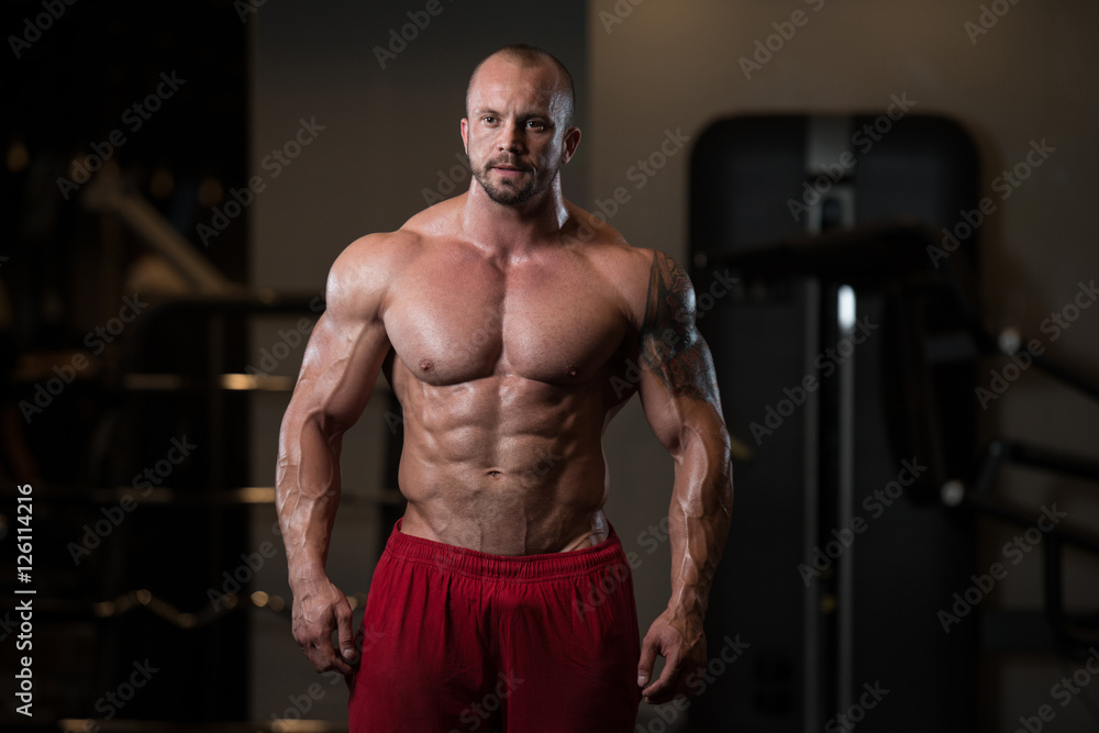 Muscular Man Flexing Muscles In Gym Muscular Man Flexing Muscles In Gym