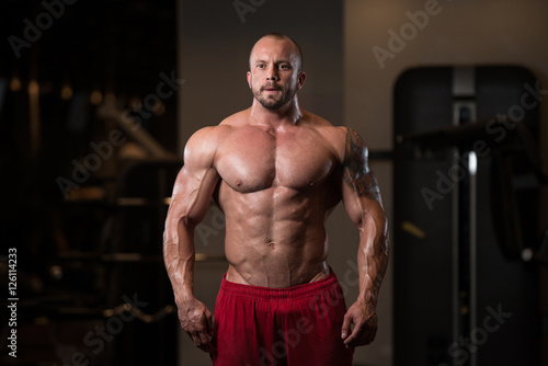 Fitness Shaped Muscle Man Posing In Dark Gym