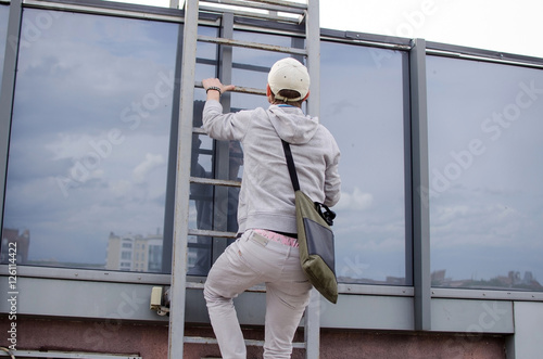 Young man climbing up to the roof