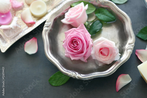 Roses in silver bowl on grey background